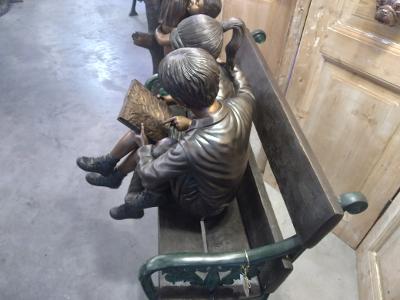 BOY AND GIRL WITH A BOOK ON A BENCH