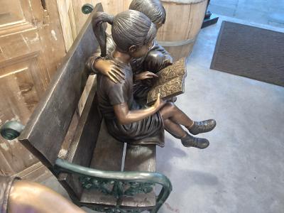 BOY AND GIRL WITH A BOOK ON A BENCH
